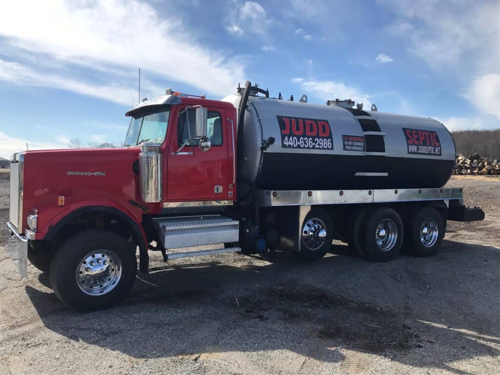 A Judd Septic Tank Cleaning truck advertises inspection and maintenance services with a phone number for customers to call.
